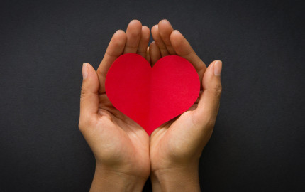 Hand holding a red paper heart